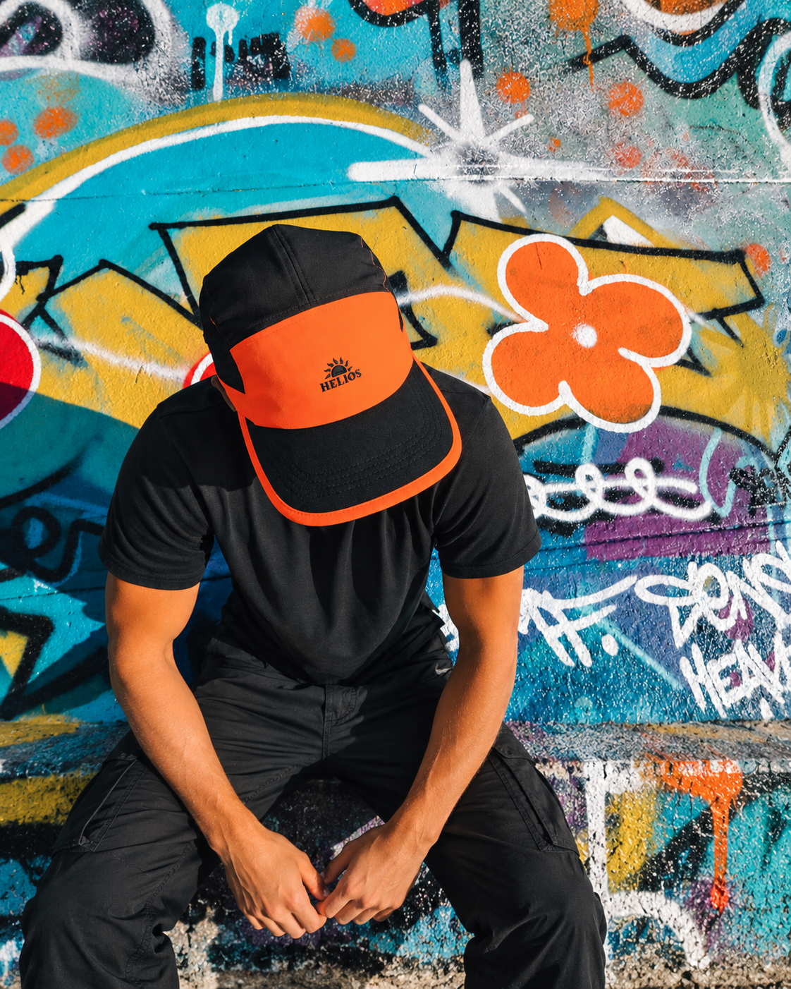 Orange Helios SpeedLid worn against colourful graffiti, enhanced with AI-extended scene for full-bleed framing