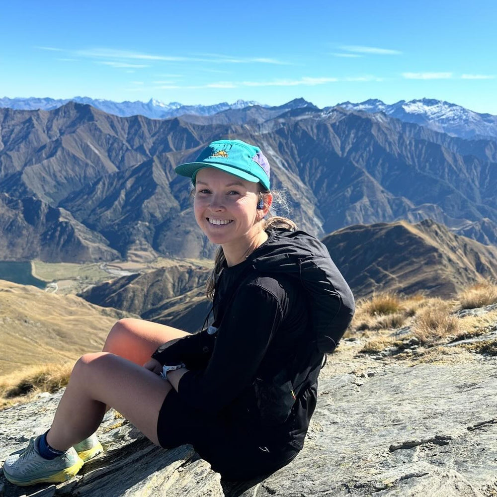 Helios Ultralight soft-brim cap in teal and purple worn on a mountain hike — catalogue H429